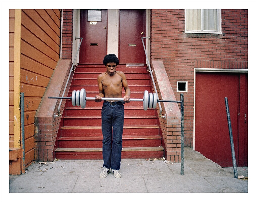 Boy lifting weights on Langton St., 1978