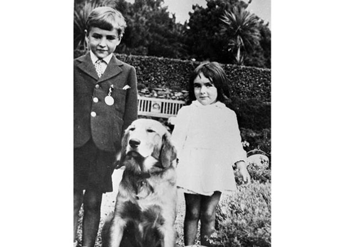 Elizabeth Taylor stands with her brother and their dog in a 