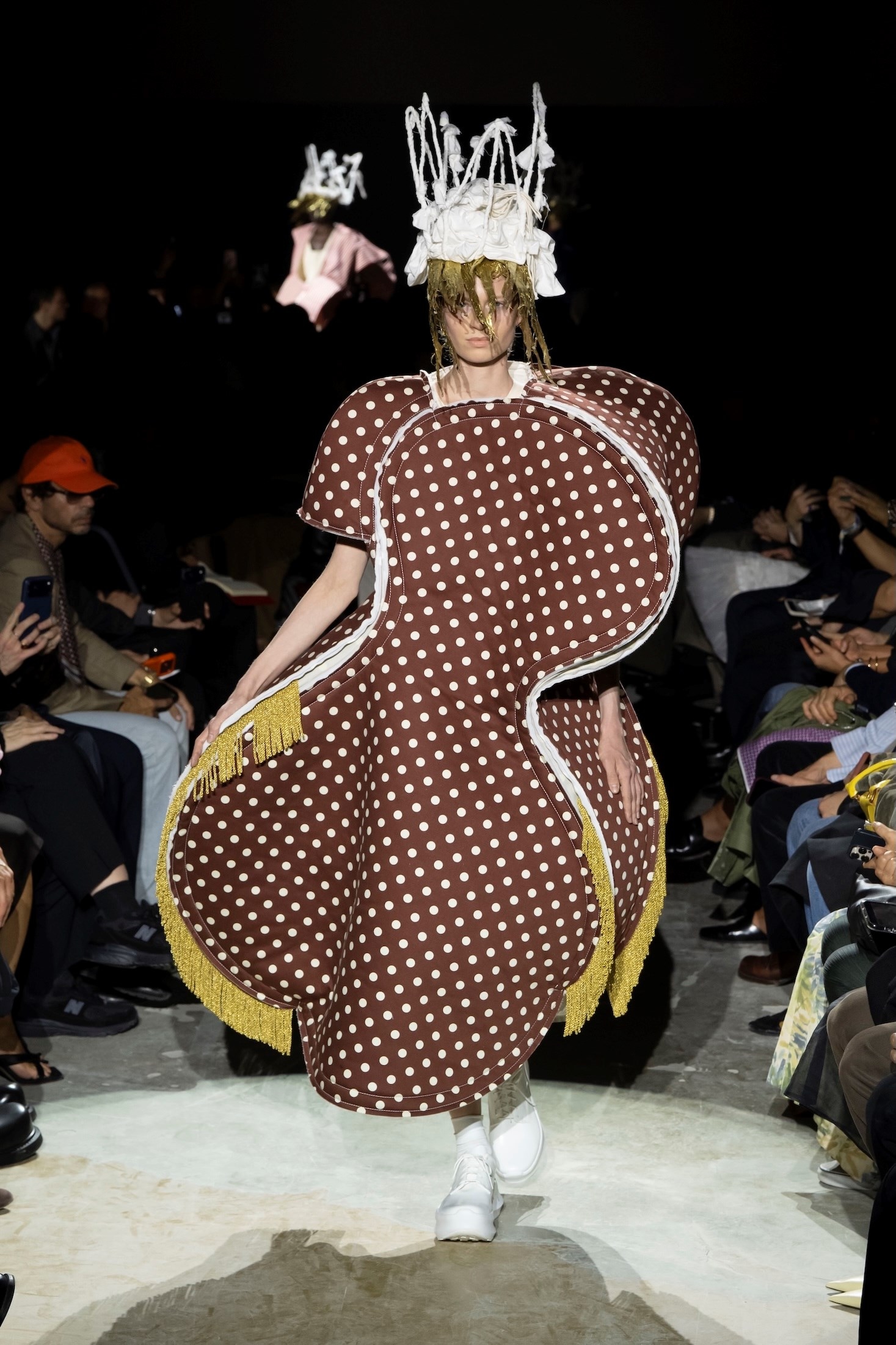 Red polka-dot Comme des Garçons SS27 padded dress inside a white plastic cage