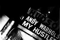Andy Warhol under My Hustler marquee at the Hudson Cinema, 1