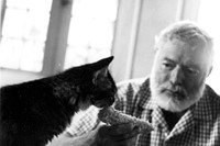 Ernest Hemingway feeds one of his cats at his villa Finca Vi