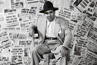 The gangster Mickey Cohen sitting amid the front pages of ne