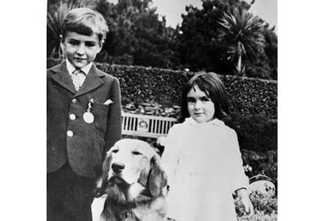 Elizabeth Taylor stands with her brother and their dog in a 