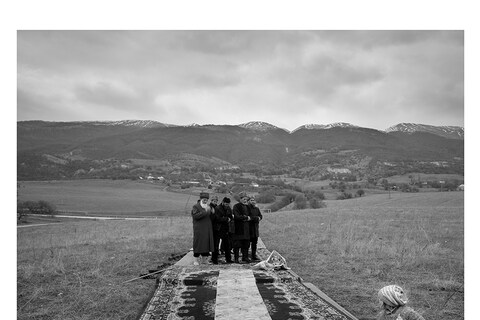 A group of elderly people praying in the mountains