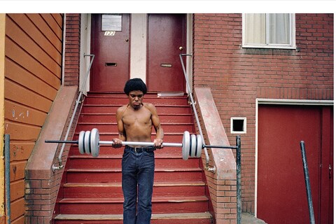 Boy lifting weights on Langton St., 1978