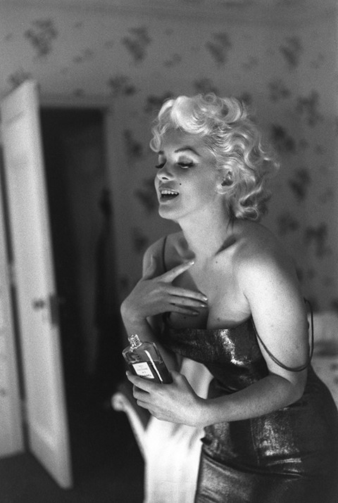 Ed Feingersh, Marilyn Monroe putting on perfume at a photo s