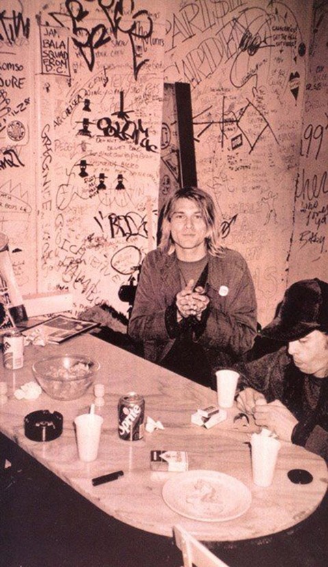 Kurt Cobain surrounded by graffiti and Dave Grohl