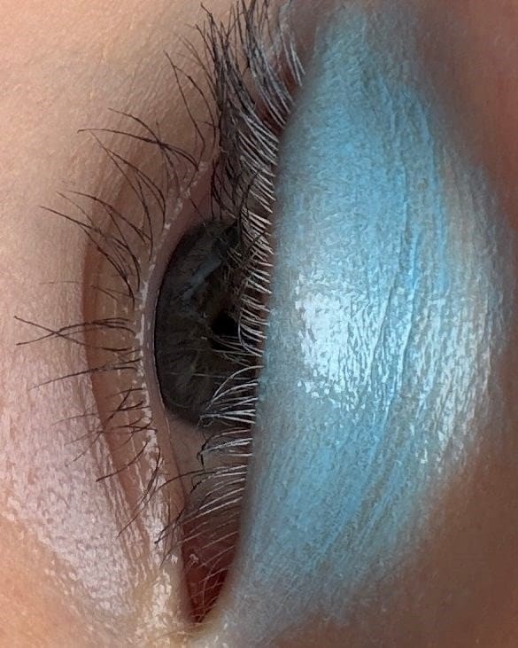 An eye with blue Fara Homidi eyeshadow on it