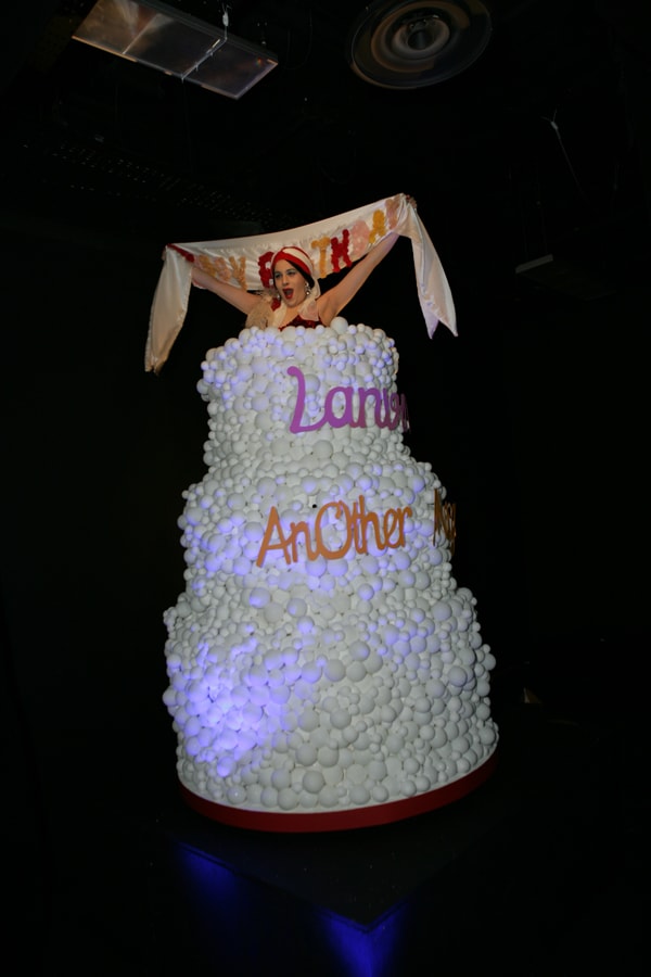 Performance artist The-O Adams inside the Lanvin cake