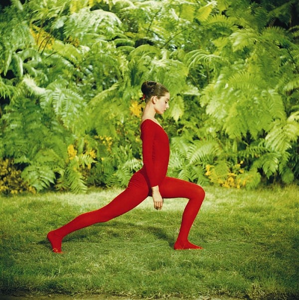 Dressed in a striking red leotard, Audrey exercises in the g