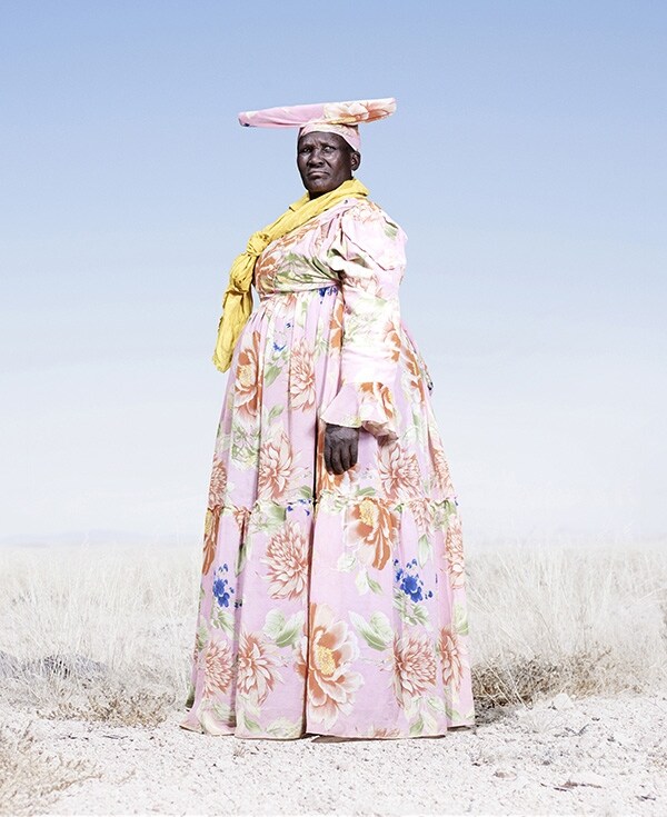 Herero woman in pink dress with yellow scarf