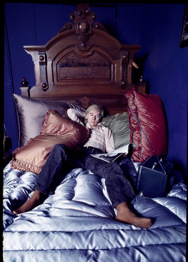 Andy Warhol on the bed of his home in New York