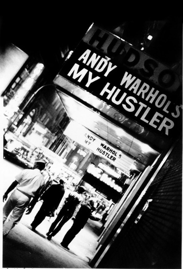 Andy Warhol under My Hustler marquee at the Hudson Cinema, 1