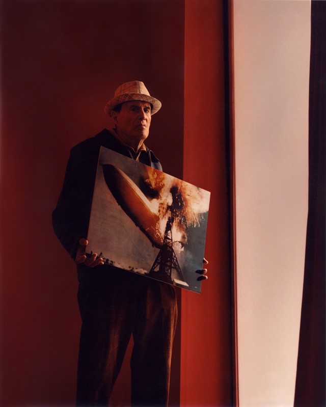 Portrait of Kenneth Anger with his print of the Hindenburg