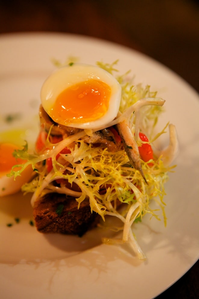 White anchovies, soft boiled egg, peppers and salad on toast