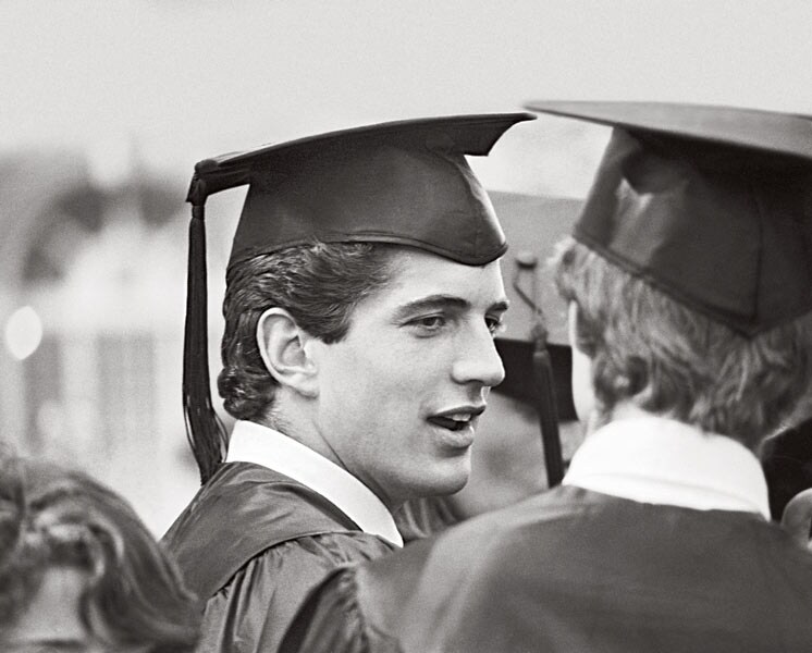 John F. Kennedy Jr. chats with a classmate at his graduation