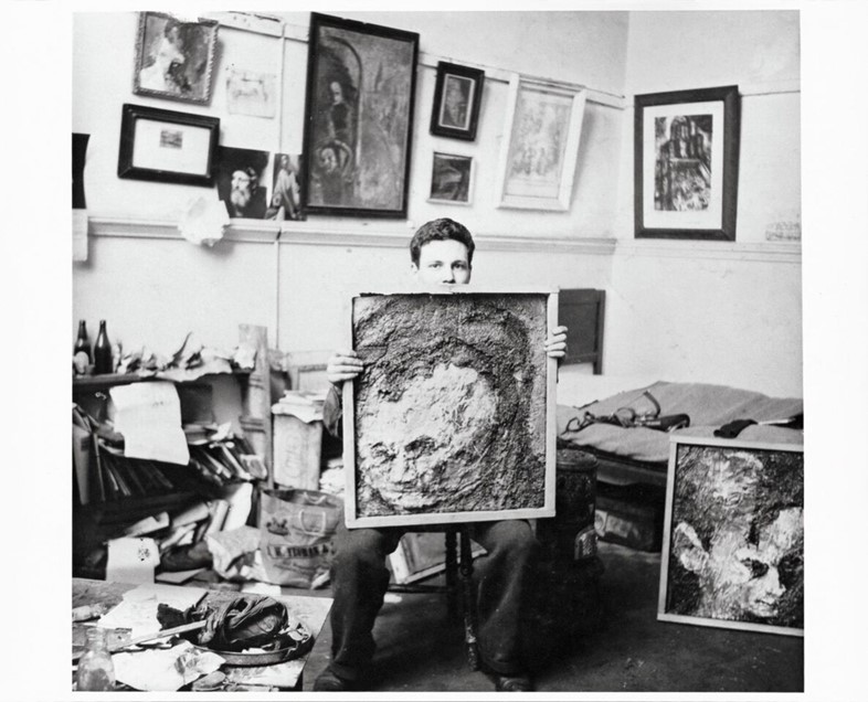 Frank in the studio with portraits of Leon Kossoff