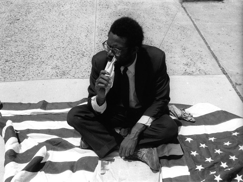 Pope.L, Eating the Wall Street Journal (Street Version) 1991