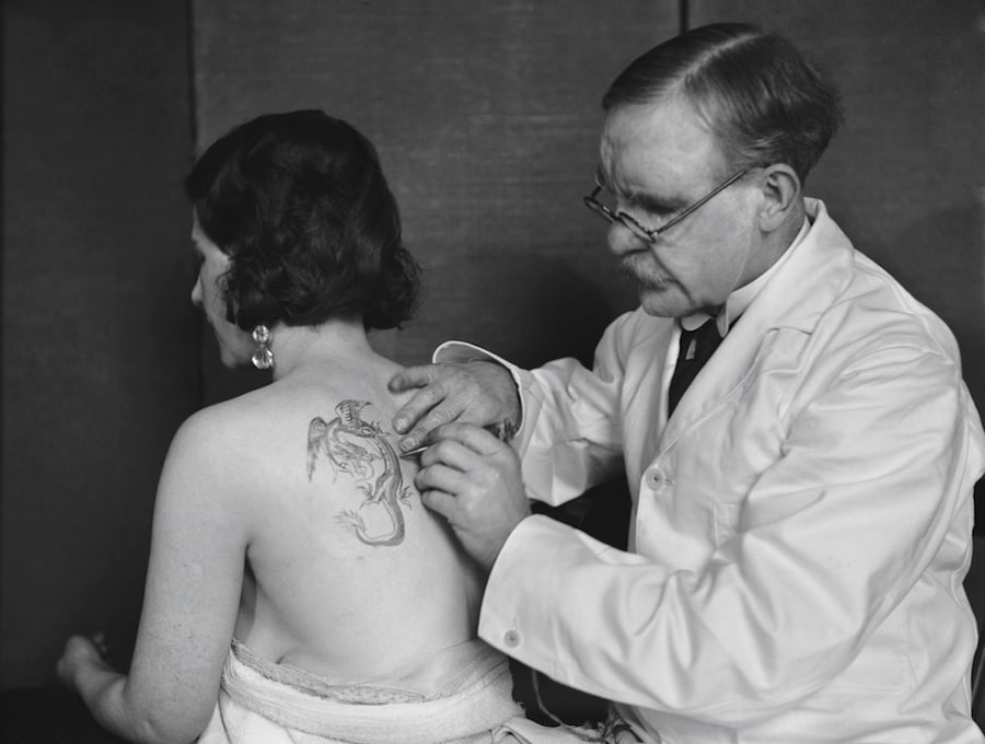Mr Burchett tattooing a woman&#39;s back, 1931