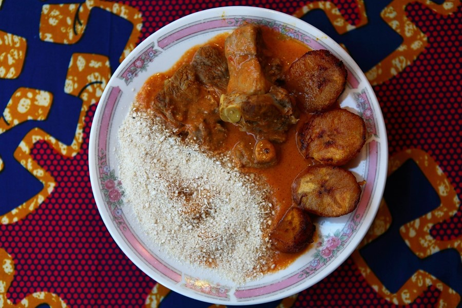 Peanut butter stew with lamb, gari, and sweet fried plantain