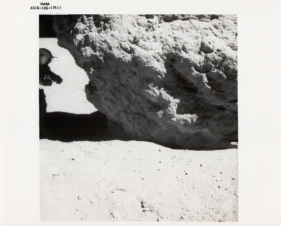 Charles Duke, John Young examines a lunar boulder, Apollo 16