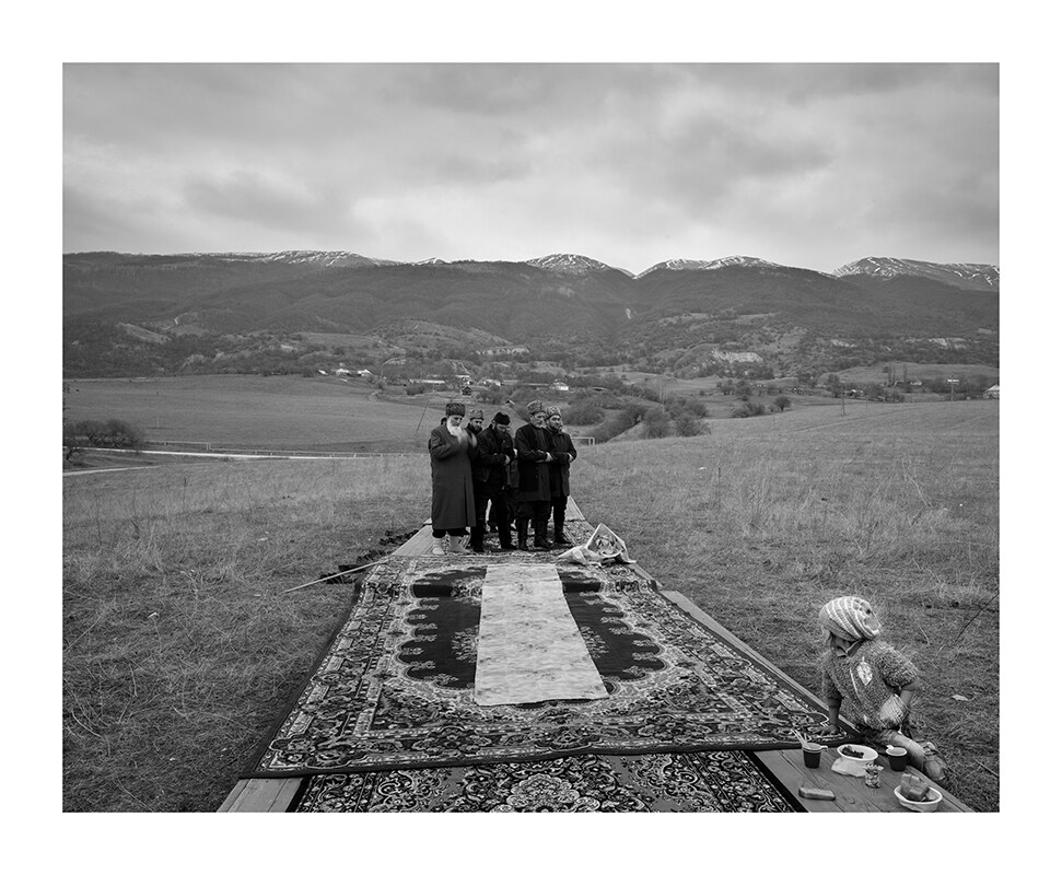 A group of elderly people praying in the mountains