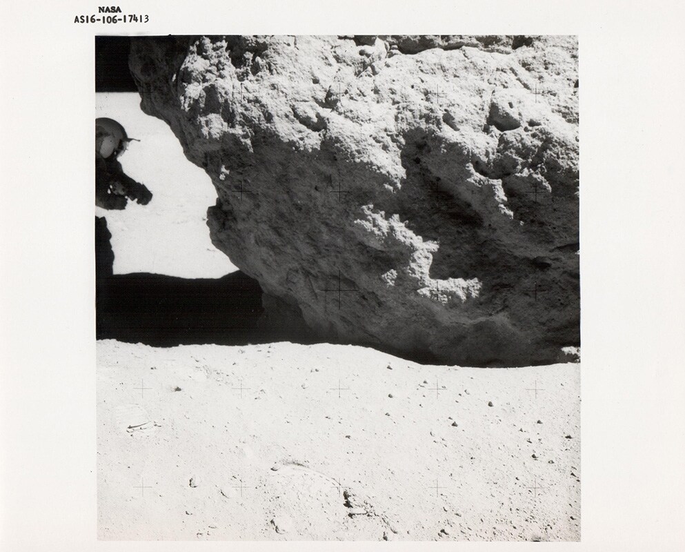 Charles Duke, John Young examines a lunar boulder, Apollo 16